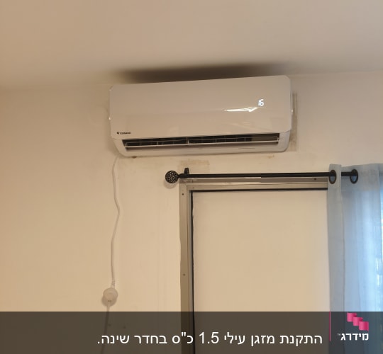 מזגן מותקן על קיר ליד חלון